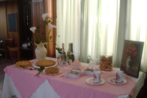 a table with a pink table cloth with food on it at Hotel Signorini in Castiglioncello