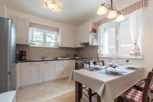 a kitchen with white cabinets and a table with a table cloth at Apartment Carpe Diem in Crikvenica +16 photos