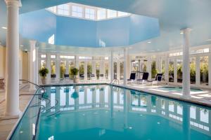 
a swimming pool with a blue umbrella in the middle of it at Wentworth by the Sea, A Marriott Hotel & Spa in New Castle
