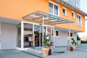 un bâtiment orange et blanc avec une grande fenêtre en verre dans l'établissement Hotel Merlin, à Leura