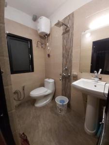 a bathroom with a toilet and a sink and a tv at Marigold Manor Homestay in Darjeeling +67 photos