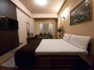 a bedroom with a large bed and a couch at Marigold Manor Homestay in Darjeeling
