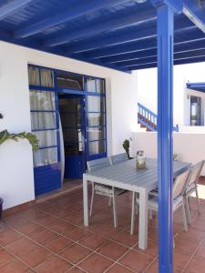 een tafel en stoelen op een patio met een blauw plafond bij Casa Mi Sol in Puerto Calero