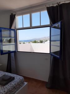 een slaapkamer met een groot raam en een bed bij Casa Mi Sol in Puerto Calero +26 foto's