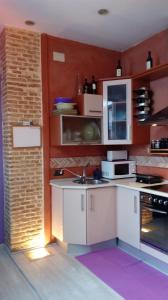 eine Küche mit weißen Schränken und einer Ziegelwand in der Unterkunft COSY DOUBLE ROOM + PRIVATE BATHROOM SEVILLA CENTER in Sevilla