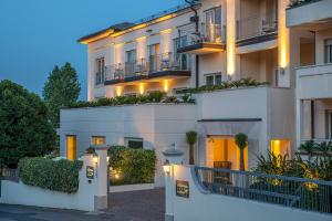 un bâtiment avec des lumières sur son côté dans l'établissement Villa Rosa Hotel Desenzano, à Desenzano del Garda