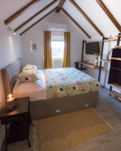 Schlafzimmer mit einem Bett, einem Schreibtisch und einem TV in der Unterkunft B&B Tara Garden in Velika Gorica