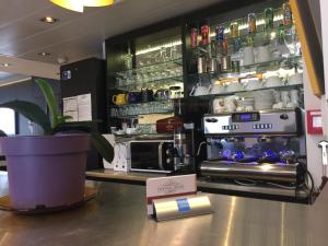 a coffee shop with a counter with a stove in a kitchen at Central Hotel in Nîmes