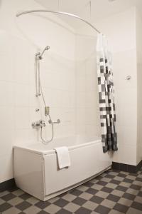 a bathroom with a bath tub with a shower at Kolonna Hotel Rēzekne in Rēzekne