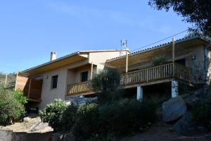a house with a balcony on the side of it at Cosy vue mer in Olmeto
