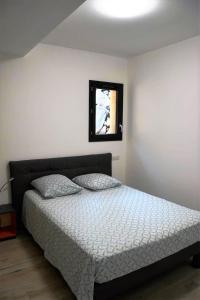 a bedroom with a bed and a window at Cosy vue mer in Olmeto