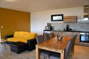 a kitchen and dining room with a wooden table and chairs at Cosy vue mer in Olmeto