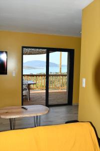 a room with a bed and a table and a balcony at Cosy vue mer in Olmeto