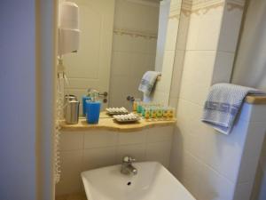 a small bathroom with a sink and a mirror at Pantonia Apartments in Agia Pelagia