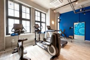 ein Fitnessraum mit Kardiogeräten in einem Raum mit blauen Wänden in der Unterkunft Catalonia Berlin Mitte in Berlin