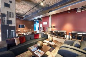 a living room with a couch and tables and chairs at Catalonia Berlin Mitte in Berlin