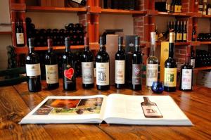 a book and a bunch of bottles of wine on a table at Fattoria di Fubbiano in Collodi