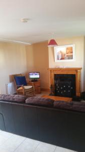 uma sala de estar com um sofá grande em frente a uma lareira em Ocean View Doogort em Doogort
