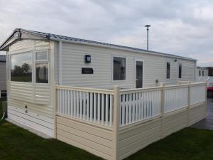 a white mobile home with a wooden fence at Flamingo Land - Cedar Wood CW09 in Kirby Misperton