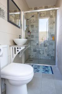 a bathroom with a toilet and a sink and a shower at Seaside Apartment in Taʼ Xbiex +5 photos