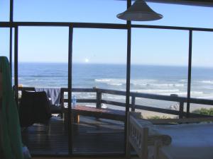 a room with a view of the ocean from a balcony at Wilderness Beach House Backpackers Lodge in Wilderness