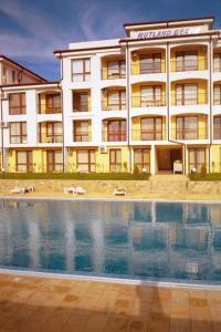 un hotel con piscina di fronte a un edificio di Apartment Rutland Beach a Ravda