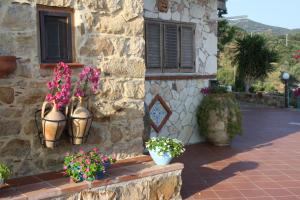 a stone building with two vases with flowers in it at Camere & Case Vacanze Lo Scoglio in Castel di Tusa