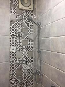 um chuveiro numa casa de banho com azulejos pretos e brancos em Al Hayaah Bayta em Tabuk