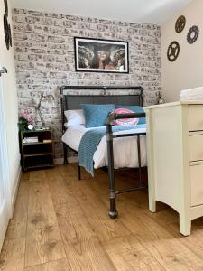 una camera da letto con un muro di mattoni e un letto di Pristine Apartment in The Centre of Glastonbury a Glastonbury