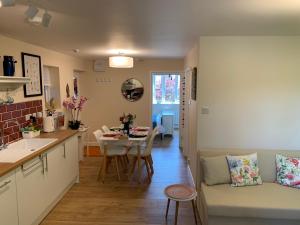 una cucina e un soggiorno con divano e tavolo di Pristine Apartment in The Centre of Glastonbury a Glastonbury