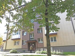 a man standing in front of a building at Šiauliai Central Spot Apartment - Draugystes pr. in Šiauliai