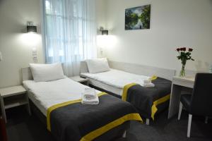 a hotel room with two beds and a desk at Centrum Restauracyjno-Hotelowe Florres in Pawłowiczki