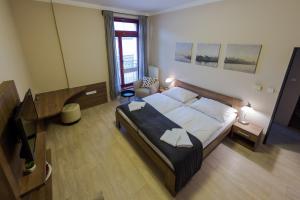 1 dormitorio con 1 cama grande y TV en Penzion Apartmány Resident, en Poděbrady