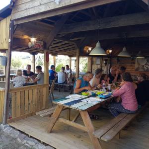 eine Gruppe von Menschen, die an einem Tisch in einem Restaurant sitzen in der Unterkunft Le Petit Moulin in Saint-Hilaire