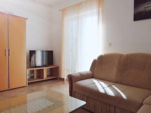 sala de estar con sofá y TV en Apartments Ćurić, en Trogir