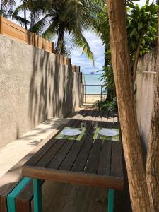 een houten tafel met een palmboom naast het strand bij Villa Sirandane in Baie du Tombeau