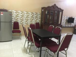 a dining room with a table and chairs and a refrigerator at Stay 707 Apartment , homestay Melaka , unit 1-11 in Malacca
