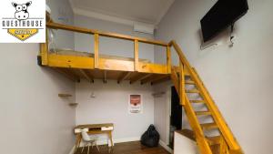Cama elevada en habitación con TV en Sabatico Travelers Hostel & Guesthouse en Buenos Aires