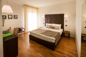 a bedroom with a large bed and a desk at Hotel Meridiana in Malcesine