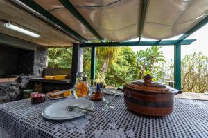 a table with a pot and wine glasses on it at Casa de Basalto in Lajes do Pico