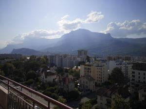 a view of a city with a mountain in the background at Les terrasses de Libération in Grenoble