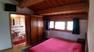 a bedroom with a pink bed and a sink at Agriturismo Al Casale in Lonigo