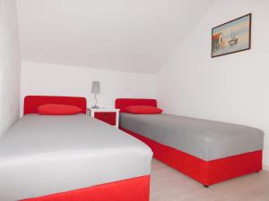 two beds in a room with red and white at Villa Renata - Apartment Bijeli in Povlja +10 photos