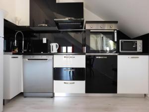 a kitchen with black and white appliances in a room at Villa Renata - Apartment Bijeli in Povlja