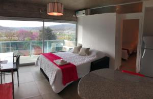 ein Schlafzimmer mit einem Bett und einem großen Fenster in der Unterkunft Departamento - Edificio Los Naranjos in San Salvador de Jujuy