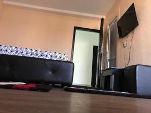 a living room with a couch and a television at Family White Hotel in Gjilan