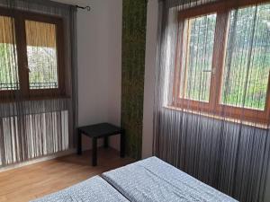 Un dormitorio con dos camas y una mesa y dos ventanas. en Mediterran Apartman, en Zalakaros 39 fotos más