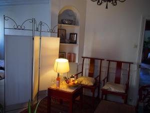 a room with a table with a lamp and chairs at Very large private room with own bathroom, in Montmartre apartment in Paris