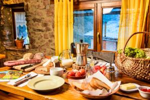 a wooden table with bread and a jug of milk at Refugi Rural Vall de Siarb in Llagunes