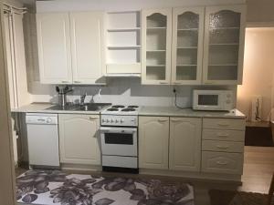 a kitchen with white cabinets and a stove and a microwave at Martantalo in Oulu